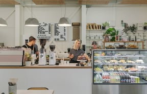 Workers in their navy and white stripped tops working behind the counter.