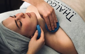 A woman draped in a blue towel getting a facial  at Total Body Concept in Christchurch.