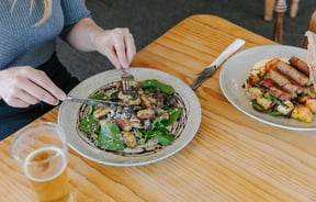 A woman about to eat a meal at a table inside Moutere Inn in  the Tasman District.