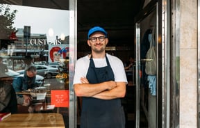 Tim Norriss standing in the door way to his cafe Customs in Wellington.