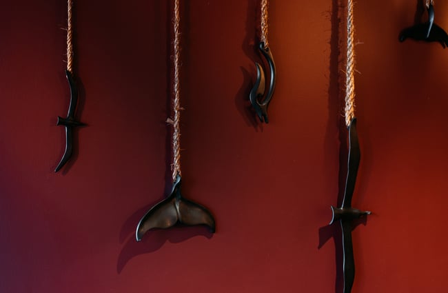 A close of decorative Maori items against a red wall.