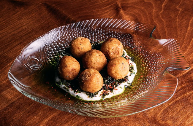 Close up of six round croquettes on a glass fish plate at 5th Street restaurant Christchurch.