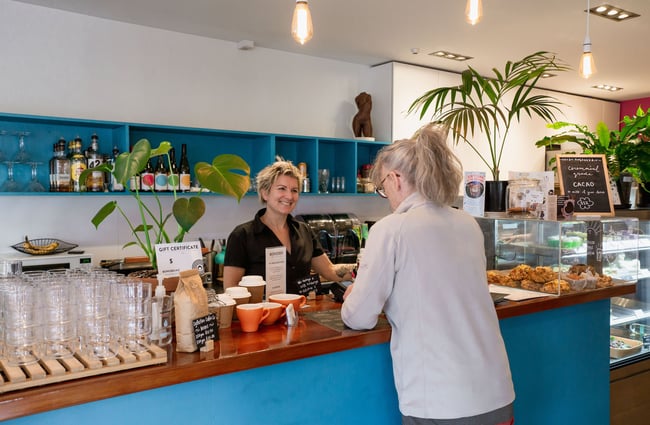 A woman orders at the blue coloured counter at Bonobo cafe, Christchurch.