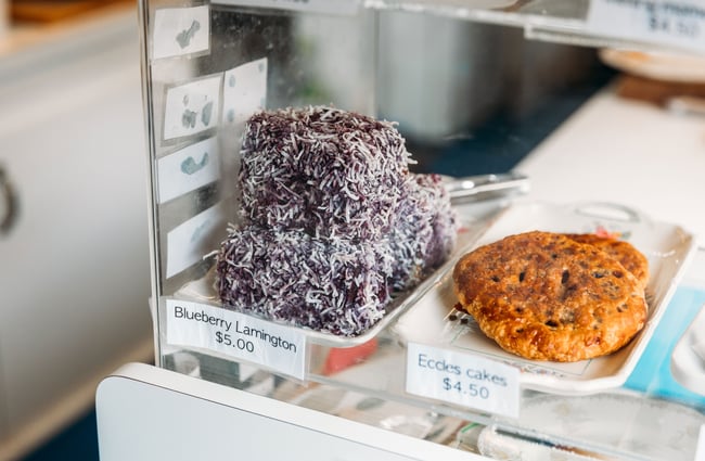 A lamington in a glass cafe cabinet.