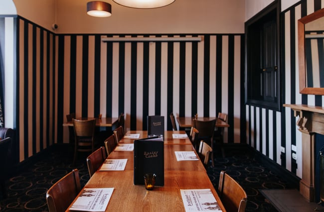A dining room with black and white stripped walls.
