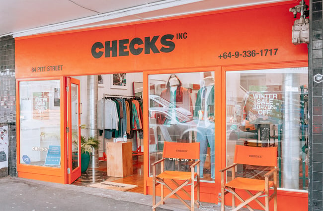 Exterior image of the bright orange store front of Checks.
