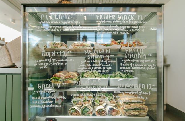 Baked goods and salads in a glass cabinet.