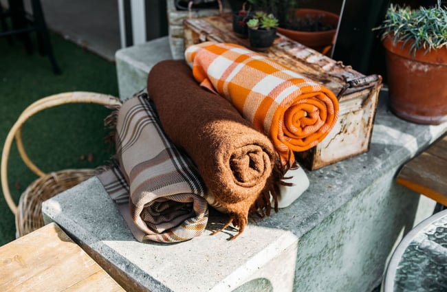 Brown and orange woollen rugs for customers to use while dining outdoors at Dripping Bowl, Wānaka.