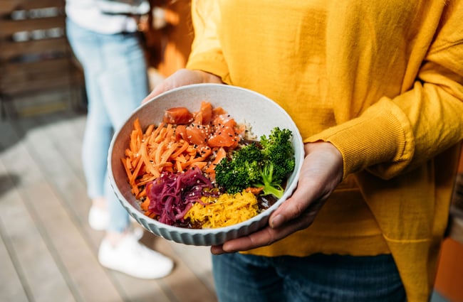 A person holds a bowl of salad of colourful vegetables at Dripping Bowl, Wānaka.