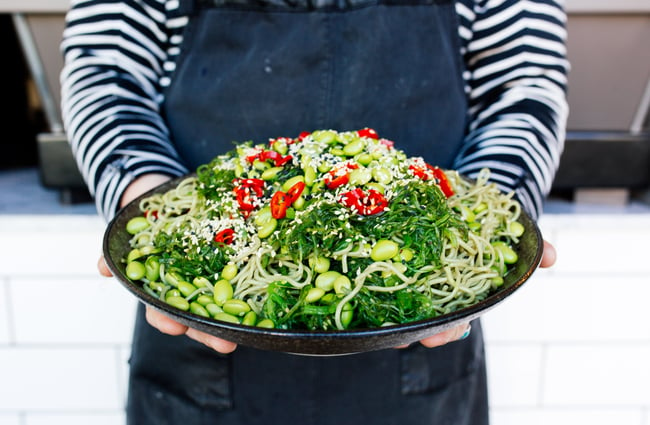 A female employee holding a plate of salad.