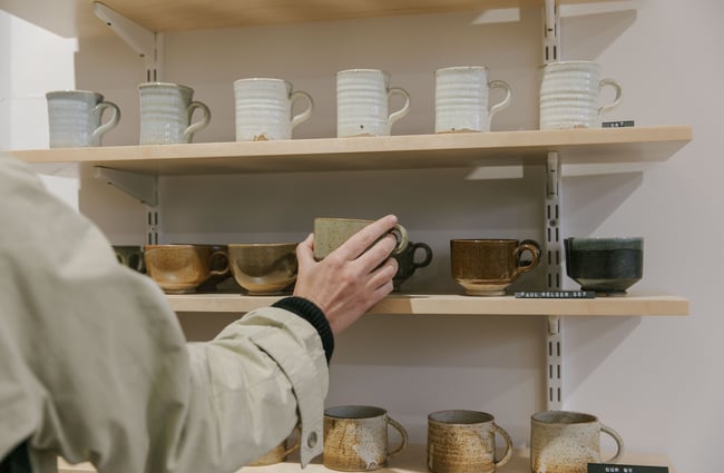 A hand holding a ceramic cup.