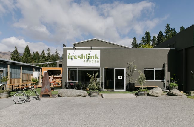 The exterior of the Freshlink Grocer in Wānaka with a green a white logo on the building.