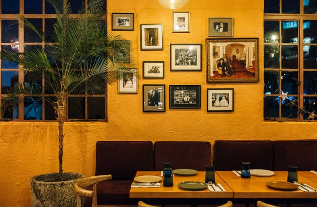 Close up of seating area and old photographs and artwork on the wall at Gemmayze Street.