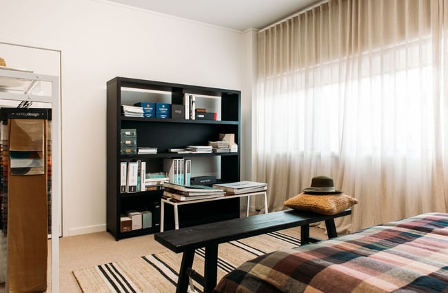 A bedroom set up on display with a book shelf and bed.