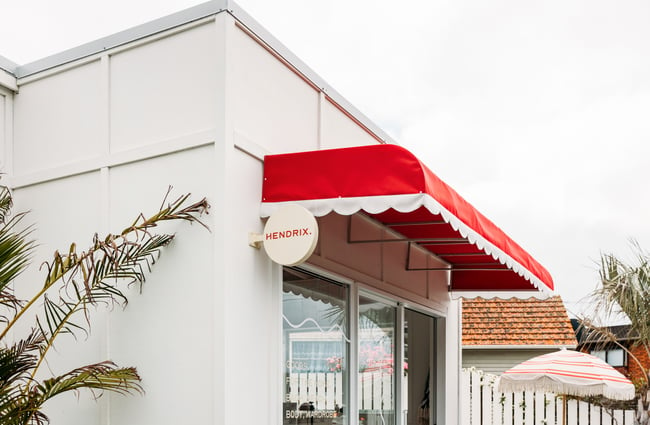 A close up of a red and white awning outside a retail store.