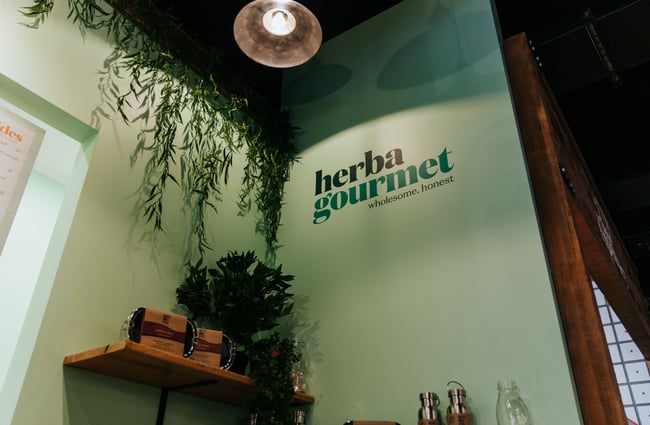 A painted Herba Gourmet sign on the interior wall.