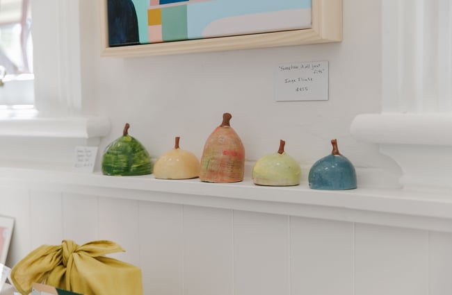 A close up of ceramic pears on a shelf.