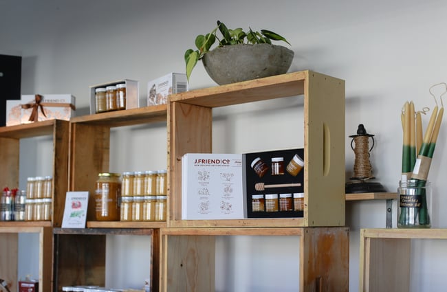 Wooden shelves filled with honey jars and plants.
