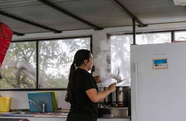 Woman standing by steaming pot at Kaikōura Seafood Bbq.