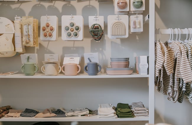 Baby bowls, cups and clothes displayed on shelves and racks in Lily and Langford Christchurch.