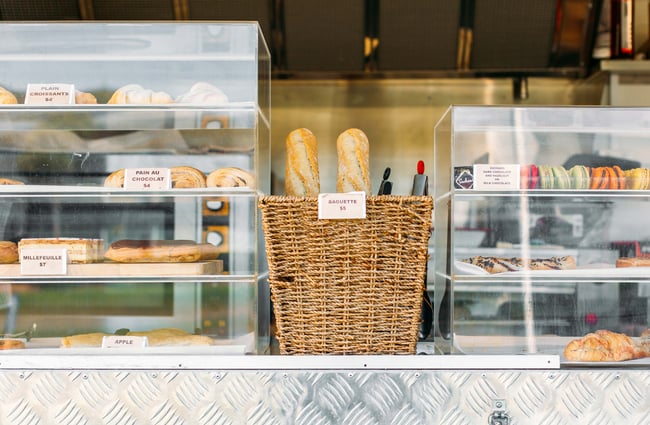 Basket of baguettes and cakes on display on the counter of the Louis by Louis Sergeant food truck in Porirua.