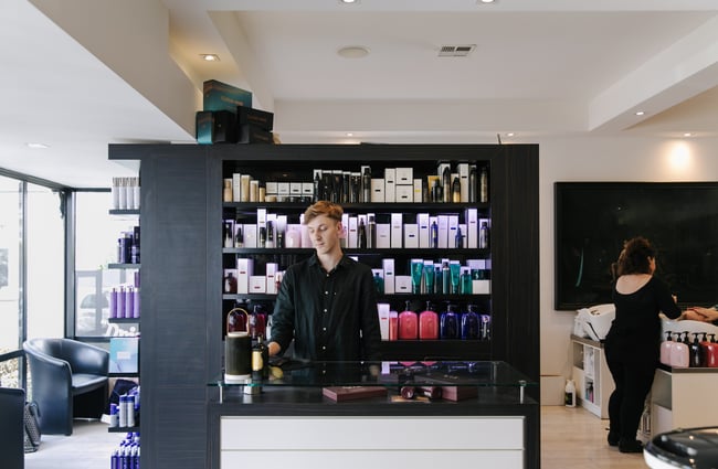 Man standing behind the front counter at Mod's Hair, Christchurch.