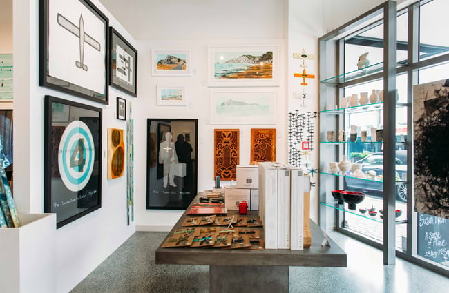 Walls filled with art inside the window of Muse Art Gallery.