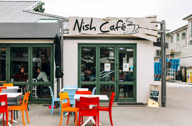 Exterior view of Nish Cafe with tables outside.