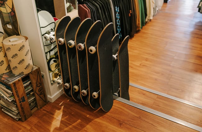 A row of skateboards lined up against the wall at Pavement, Dunedin.