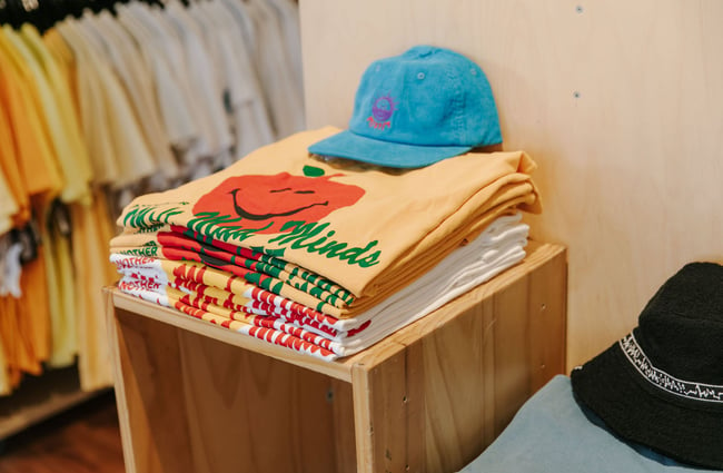 Stack of yellow tees with retro style cord hat on top at Pavement, Dunedin.