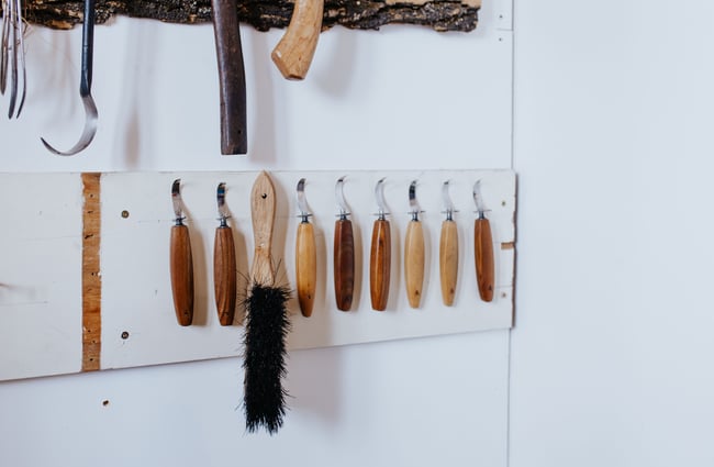 Items made of wood hanging on a white wall.