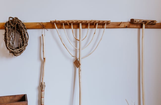 Wooden rakes hanging on a wall.