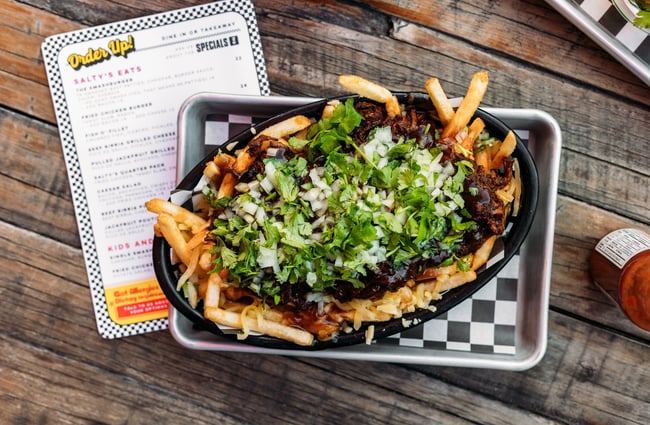 A Birdseye view of loaded fries in a bowl.