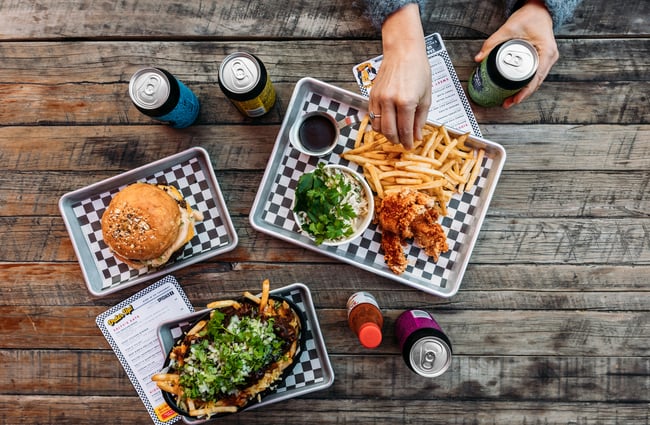 A flatlay of burgers and chips on a table.