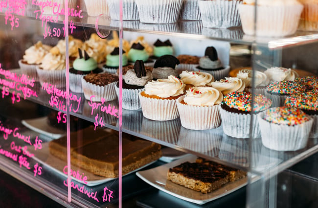 A close up of cupcakes in a glass cabinet.