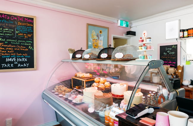 A glass cabinet full of sweet treats inside a cafe.