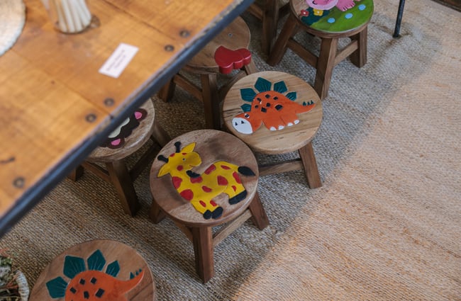 A close up of wooden chairs with cute colourful pictures on them.