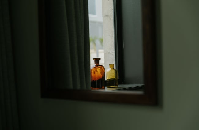 A close up of two little jars can window sill.