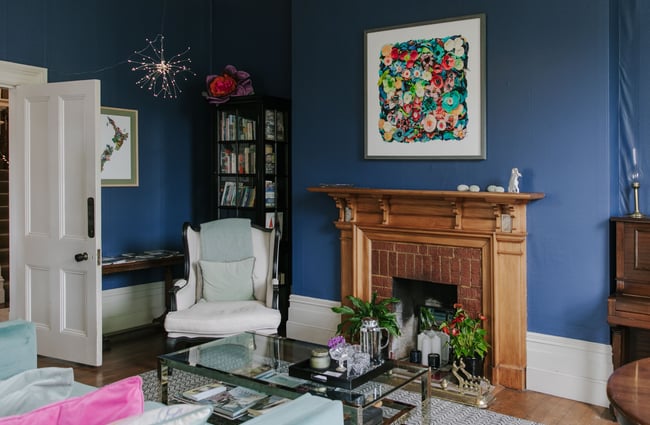 A lounge with blue painted wall and fireplace at The Vicarage.
