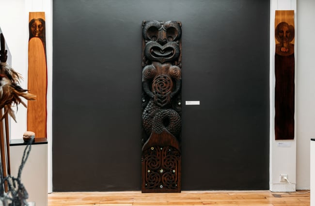 A sculpture on display in front of a black wall.