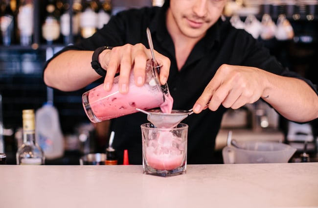 A staff member making a cocktail.