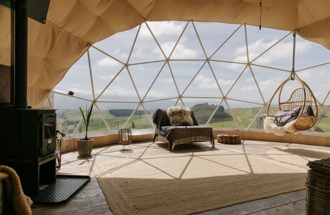 Inside a Glamping pod with a big clear window looking out over the view.