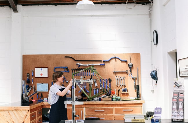 Charlotte fixing a bike at Action Bicycle Club in Christchurch.