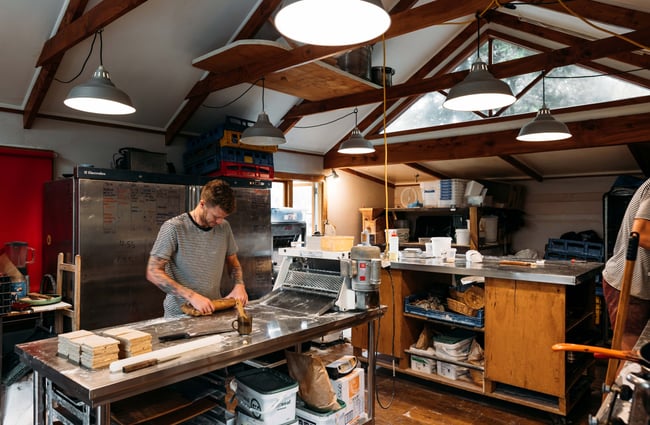 A staff member in the kitchen making bread.