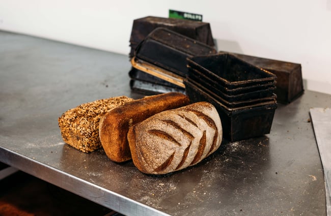 Three loaves of bread on a counter.