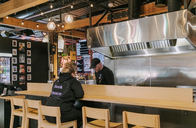 Someone sitting at the counter talking to the chef.