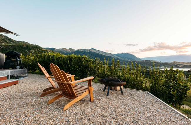 Seating area looking towards hills and the ocean at sunset.