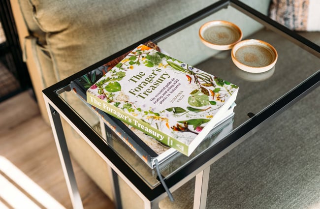 A couple of coffee table books on a glass table.