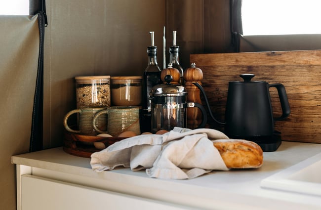 Tea, coffee and fresh bread on a bench.