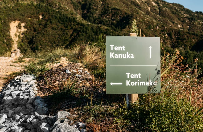 A green and white sign directing people to the tents at Drift Off.